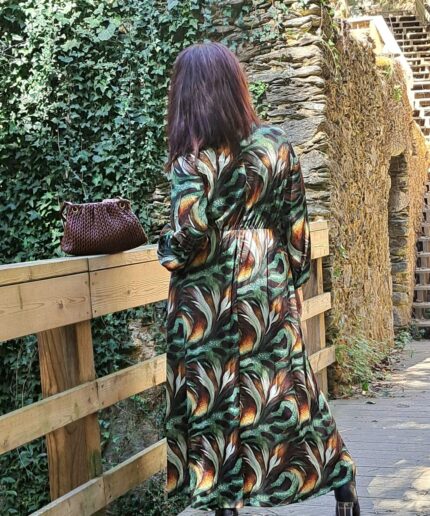 Mulher com vestido comprido em zona arborizada numa ponte de madeira