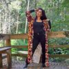 Mulher com roupa preta e um kimono colorido rodeada de árvores