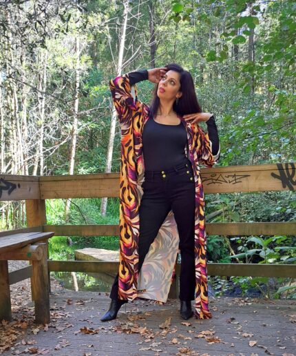 Mulher com roupa preta e um kimono colorido rodeada de árvores