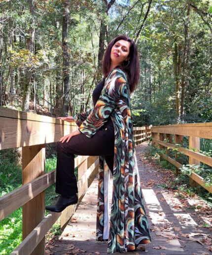 Mulher com roupa preta e um kimono colorido rodeada de árvores