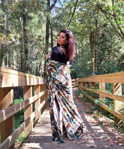 Mulher com roupa preta e um kimono colorido rodeada de árvores