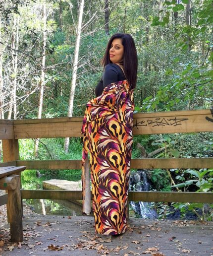 Mulher com roupa preta e um kimono colorido rodeada de árvores