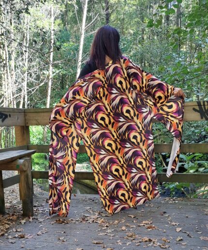 Mulher com roupa preta e um kimono colorido rodeada de árvores
