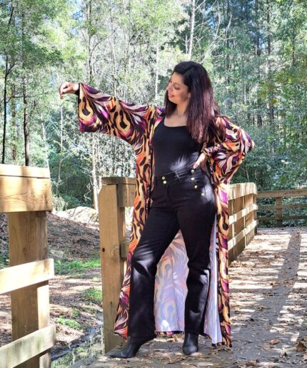 Mulher com roupa preta e um kimono colorido rodeada de árvores