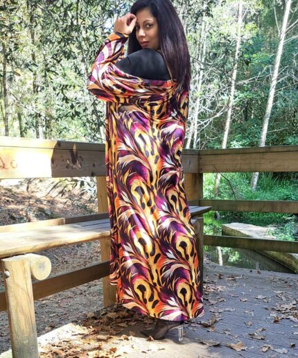 Mulher com roupa preta e um kimono colorido rodeada de árvores