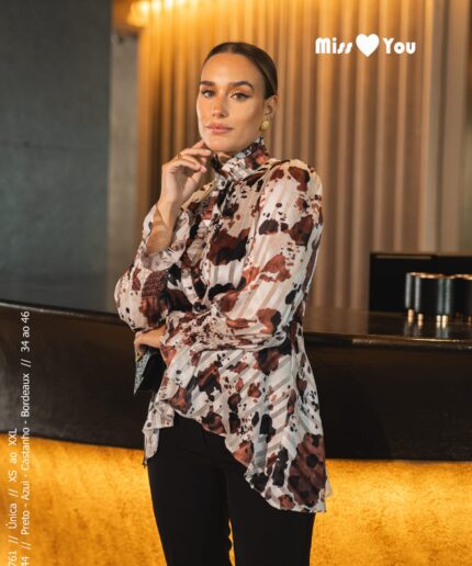 Mulher de cabelo apanhado perto de um balcão luxuoso com uma blusinha estampada da Miss You