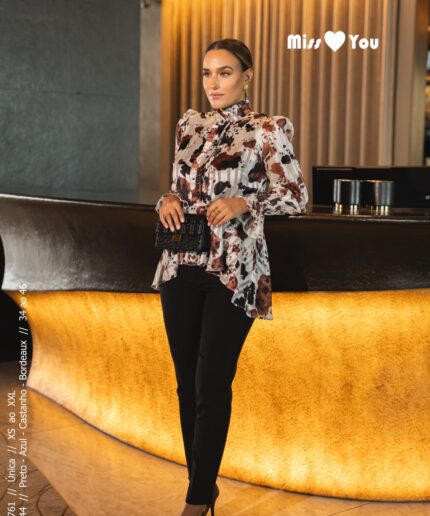Mulher de cabelo apanhado perto de um balcão luxuoso com uma blusinha estampada da Miss You