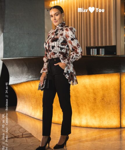Mulher de cabelo apanhado perto de um balcão luxuoso com uma blusinha estampada da Miss You