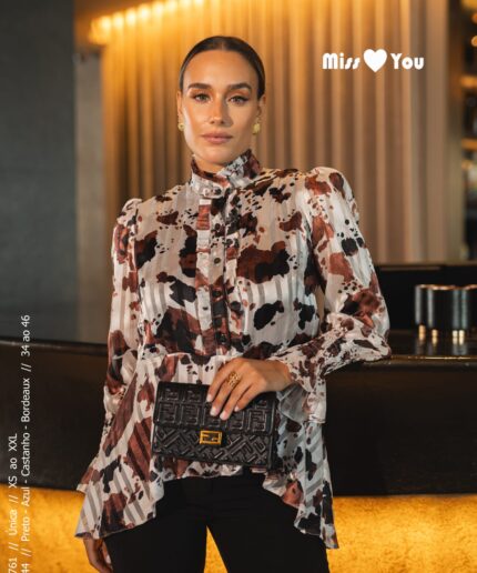 Mulher de cabelo apanhado perto de um balcão luxuoso com uma blusinha estampada da Miss You